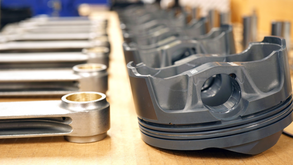 row-of-pistons-connecting-rods-on-table-1024x578-1 row of pistons & connecting rods on table
